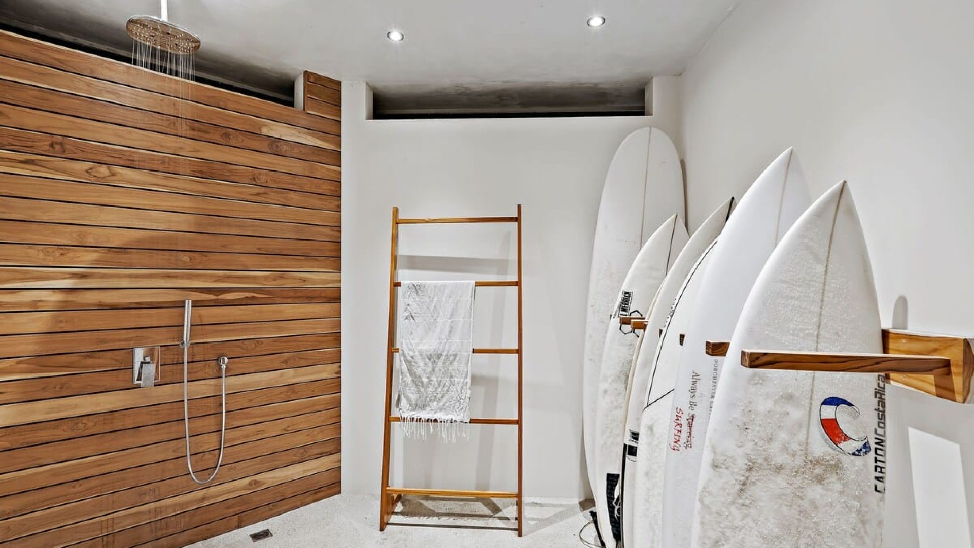 After a beach day and before getting inside the house, next to the Garage area is the shower and surfboard rack